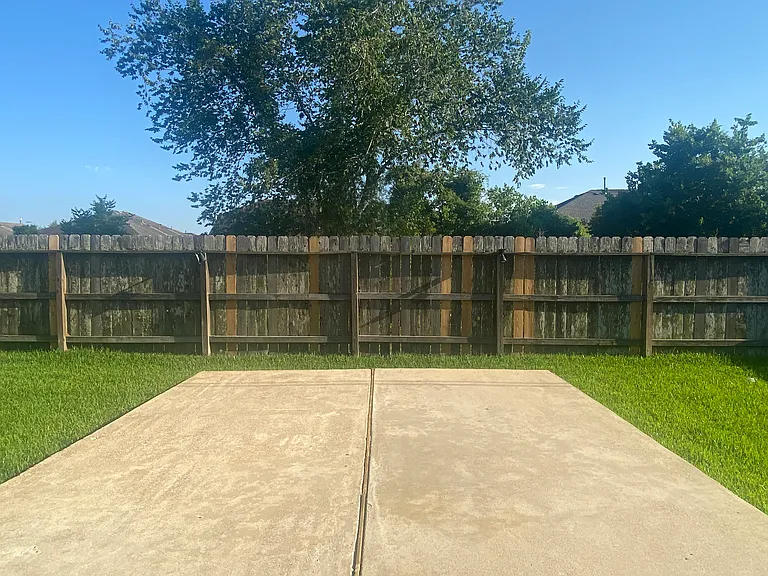 Backyard with an extended concrete slab _ the perfect setup for grilling and outdoor entertaining.