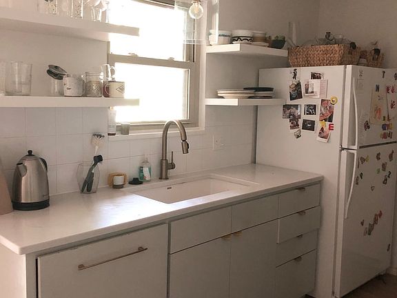 The kitchen is a galley kitchen that connects the front living room and the sunroom. You can reach the garage through the kitchen.