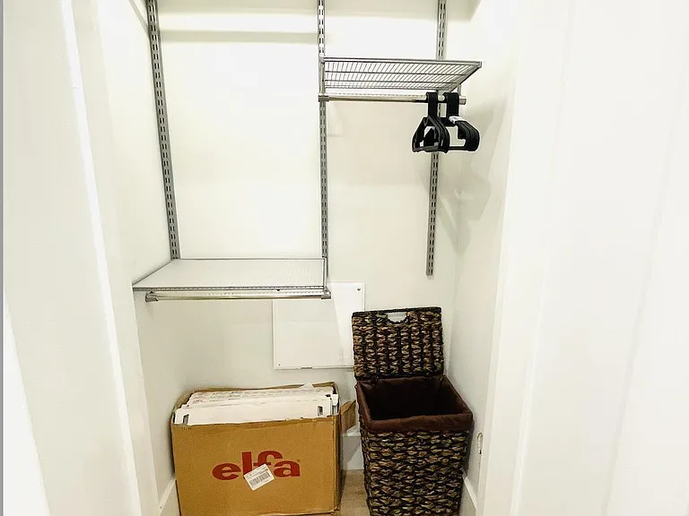 Elfa closet organizing system with lighting.