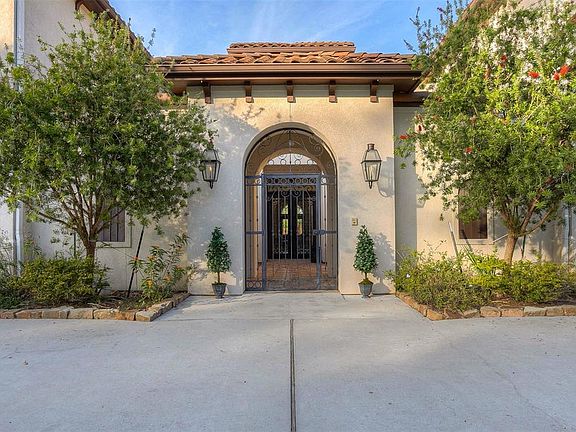 This wonderful mediterranean home has a dramatic courtyard entrance through the wrought iron gates.