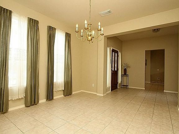 Step into the foyer through  a leaded glass door onto tile flooring that extends into the large formal dining room.
