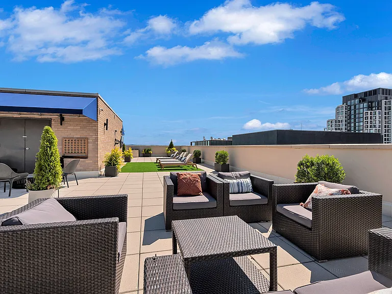 A patio with black furniture and a blue sky.