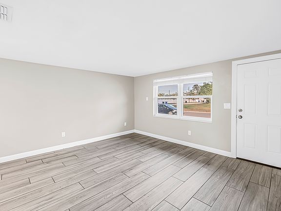 Large open-concept living room with beautiful view of front yard.