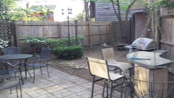 Private fenced in back yard with patio furniture and storage