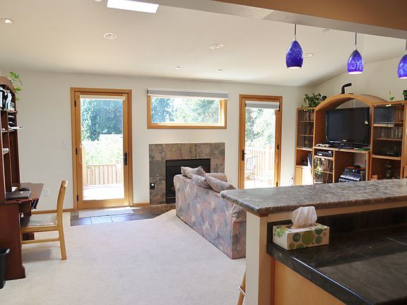 Bright family room with skylights, bar and stools facing kitchen