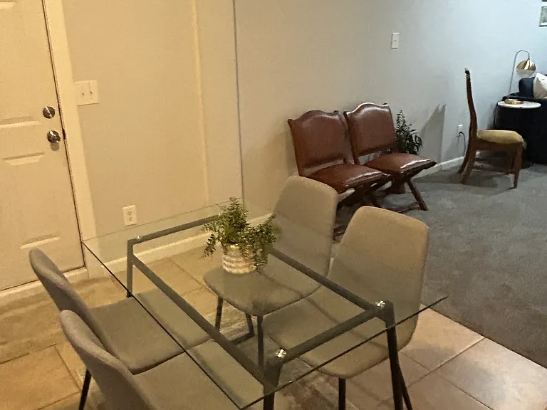 DINING AREA IS A STEP DOWN FROM THE KITCHEN WITH GLASS DINING TABLE. ADDITIONAL SEATING LEADING INTO THE REC AREA.
