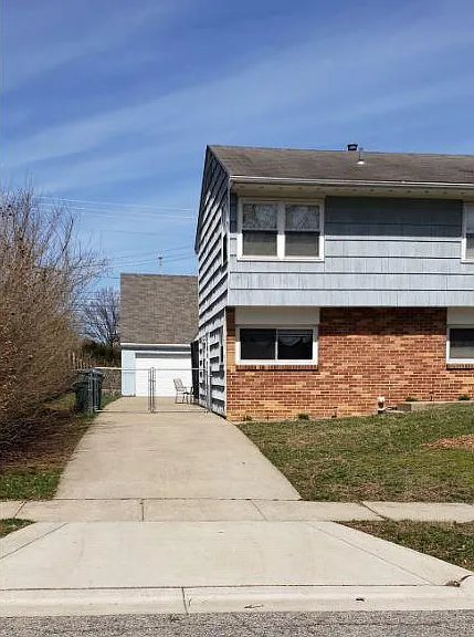 Concrete driveway with gated access to backyard