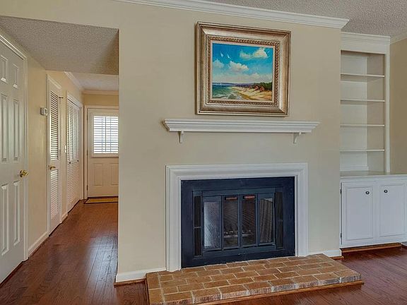Fireplace and built-in bookcase in the living room. Half bath is the first door on the left, leading to the kitchen.