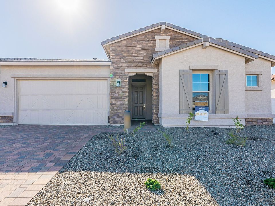 Elegant stone facade and custom shutters enhance this Sycamore Farms residence s southwest charm.