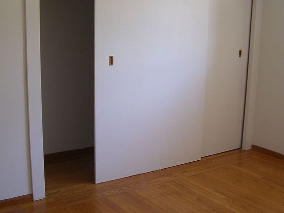 One of the bedrooms with detail of the original hardwood floors.