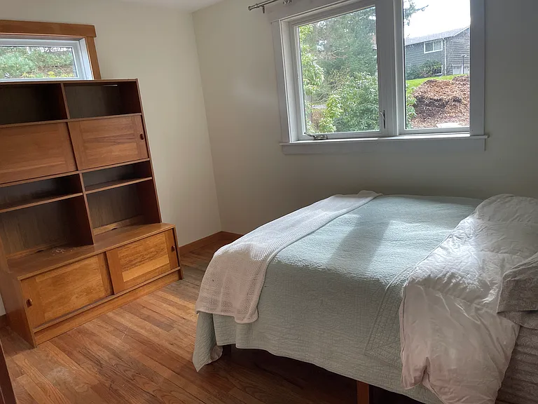 Medium size bedroom showing west and south facing windows. Your choice of available. furnishings.