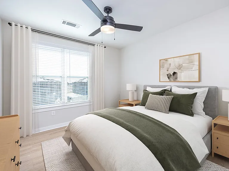 Townhome primary bedroom with hard-surface vinyl plank flooring and ceiling fan