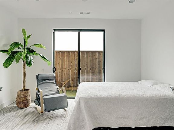 Bedroom on the first floor with upgraded tile, en-suite bathroom, and access to the back yard.
