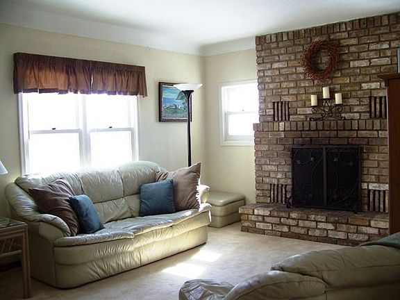 Living room features coved ceiling and brick fireplace.
