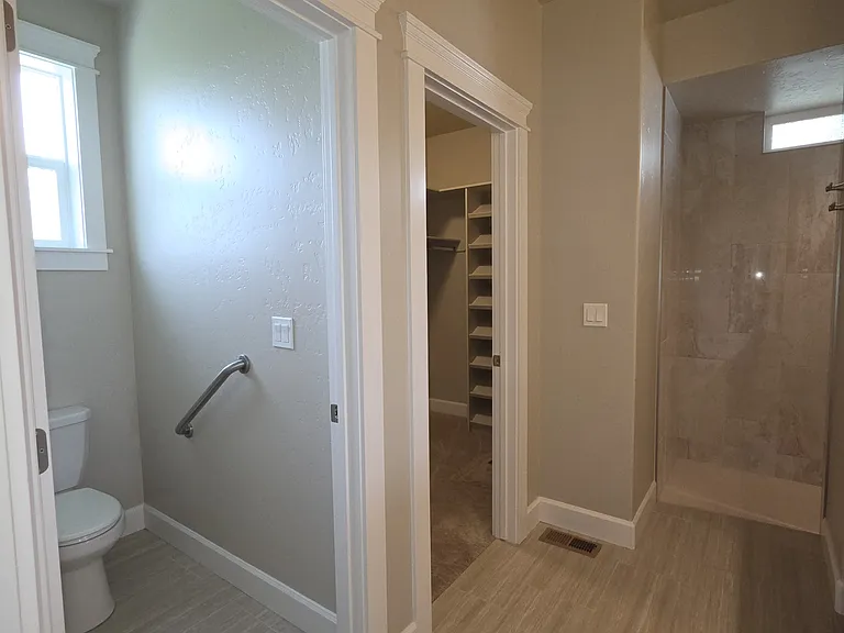MASTER BATHROOM WITH SAFETY HANDLE FOR RESTROOM.