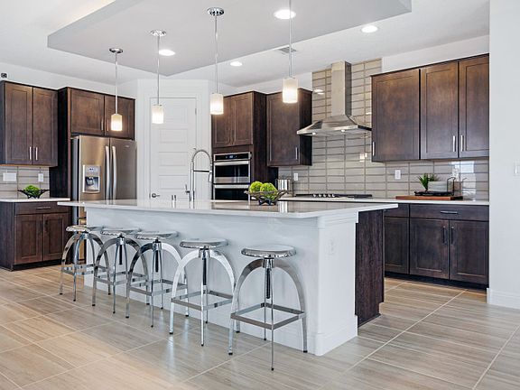Staggered cabinets, designer pendant lights, and built-in stainless appliances show off the Parklane