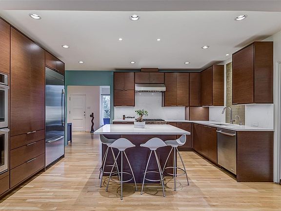 Kitchen New in 2017! Custom Euro-style Starmark cabinets, center island, quartz counters, and high-end appliances. View of entry and living room beyond.