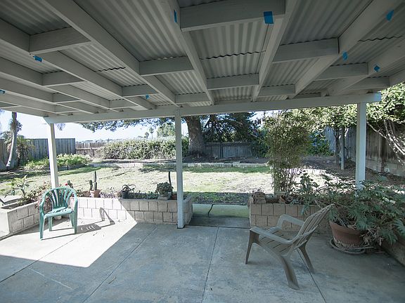 Covered rear patio with planters. Purple trumpet vine on right. King palms on left. Facing West for sunsets.