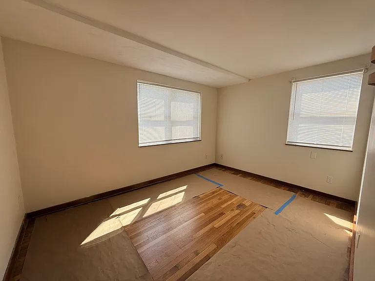 Bedroom 2 with protective paper on newly refinished hardwood floors