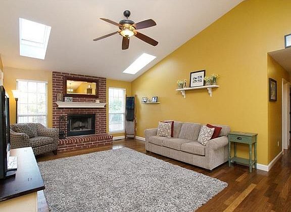 Wood burning fireplace, vaulted ceiling, skylights & gleaming wood floors make this Great Room...GREAT