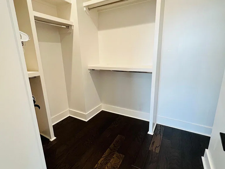 Master closet with additional shelving behind the wall on the right