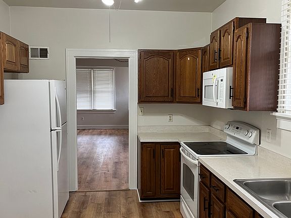 Kitchen with refrigerator, electric stove, garbage disposal, and microwave