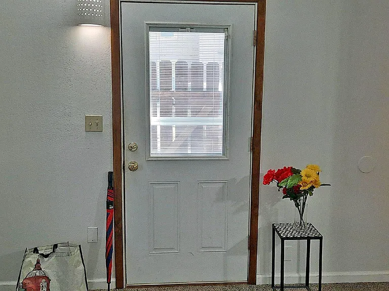 ...the front door has blinds in the window offering daylight or privacy options...