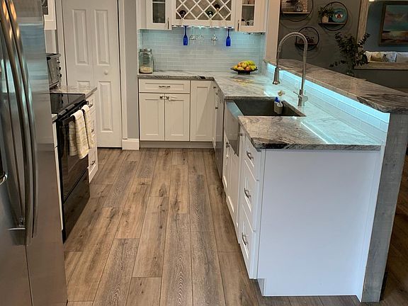 Kitchen boast oversized farmhouse sink, newer appliances, wine rack and full size pantry