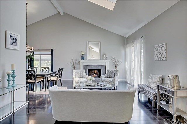 Elegant Formal Living room with designer fireplace, newer Hardwood floors and vaulted ceiling