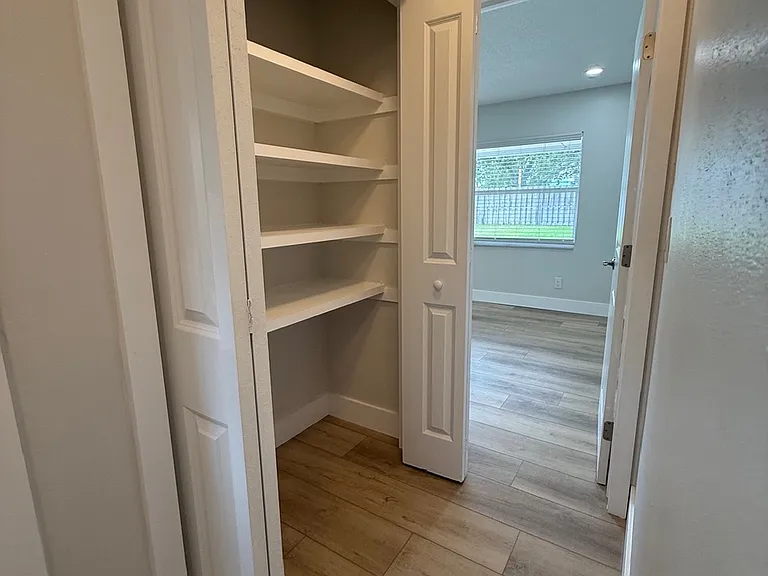 Hallway to back bedroom, linen closet