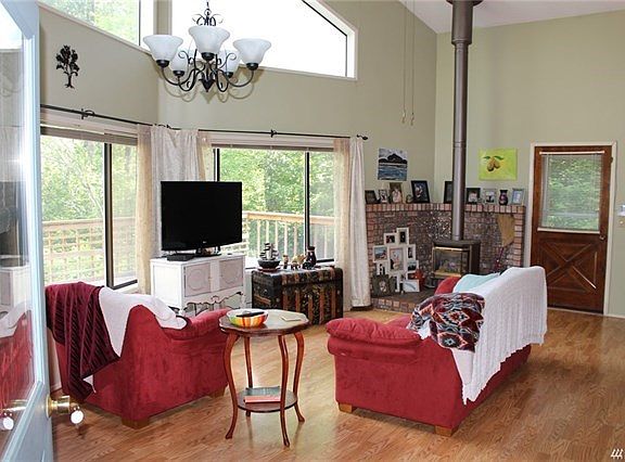 Soaring vaulted ceilings and wood stove keep things cozy.   Newer laminate flooring throughout main floor perfect for beach feet.