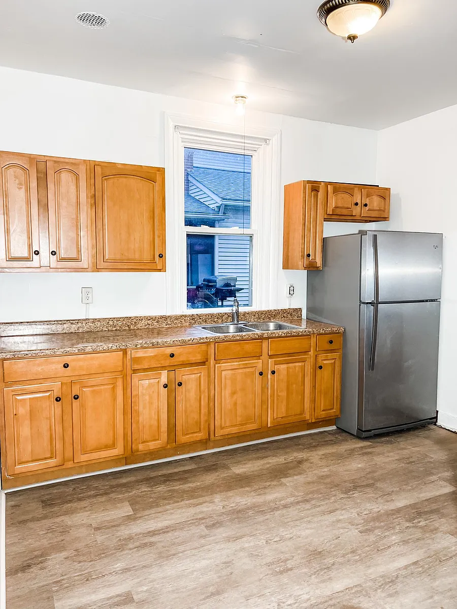 The back door enters into the eat-in kitchen. There is a brand new refrigerator and range in the kitchen. - 153 W Frederick St