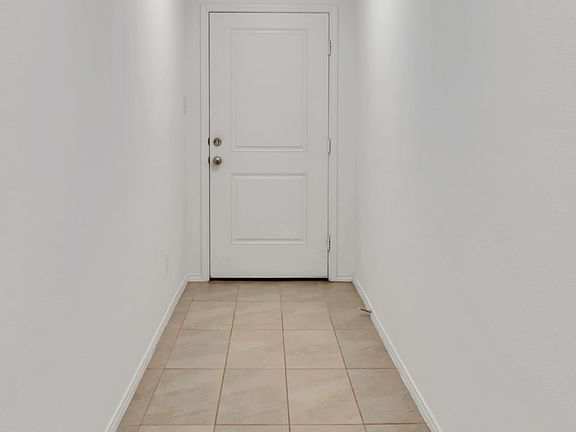 Corridor with light tile patterned floors and recessed lighting