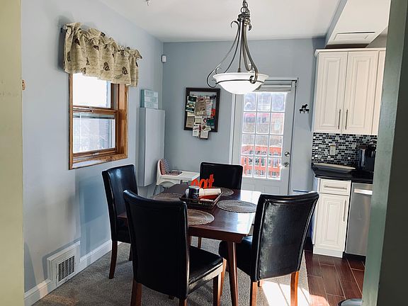 Table for four and a high chair for the little one. Letter chairs and cherry wood table. The dining room is approx. 6'7"x10'