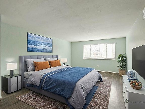 Inviting bedroom with a plush queen-sized bed, elegant decor, and peaceful ocean-themed artwork, bathed in natural light.