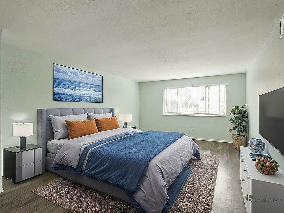 Inviting bedroom with a plush queen-sized bed, elegant decor, and peaceful ocean-themed artwork, bathed in natural light.