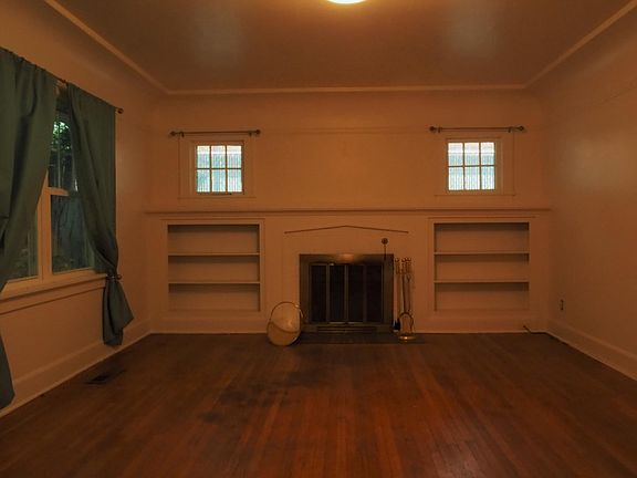 Large living room with fireplace, built-ins, and hardwoods