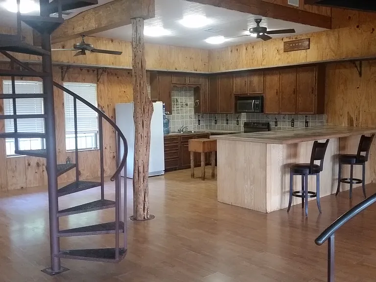 Spiral staircase leading to storage area/bedroom with 1/2 bath