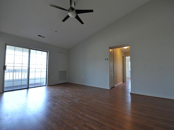 living room with high vaulter ceiling and ceiling fan