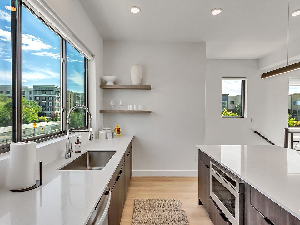 kitchen featuring open floor plan, a center island, wood finishes floors, and stainless steel microwave