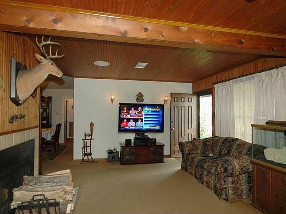   Another view of the opposite side of the living room-fantastic custom woodwork on the walls and ceilings! To the left is the wood burning fireplace and the dining room.