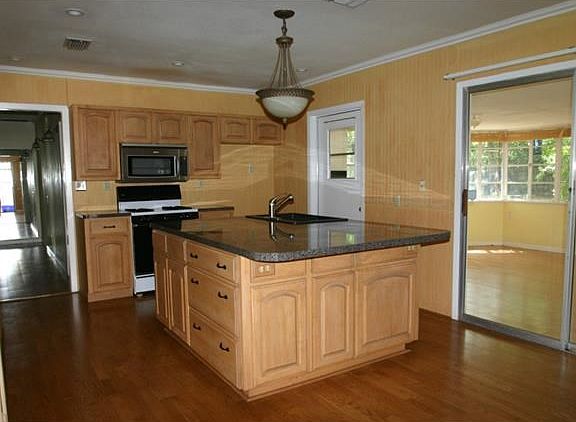 Kitchen features a large island with sink and dishwasher, wo