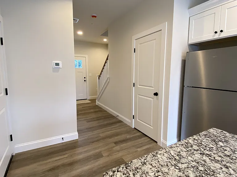 View from granite island, garage access on left, mechanical closet on right next to fridge