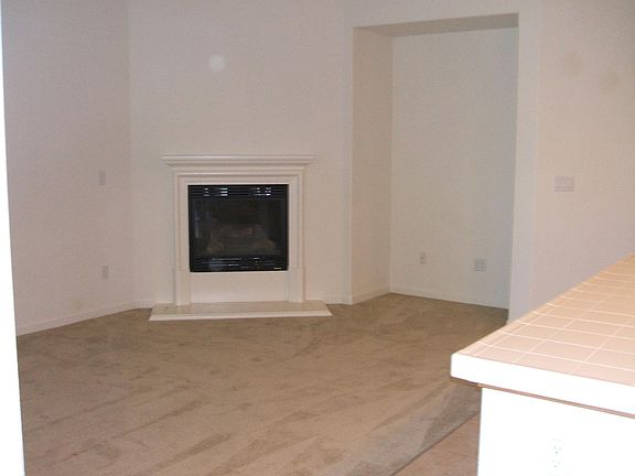 Family room with bar/countertop open to kitchen with gas fireplace.
