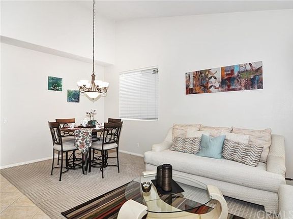 Enter into a inviting and light-filled formal living room and dining room with vaulted ceilings.