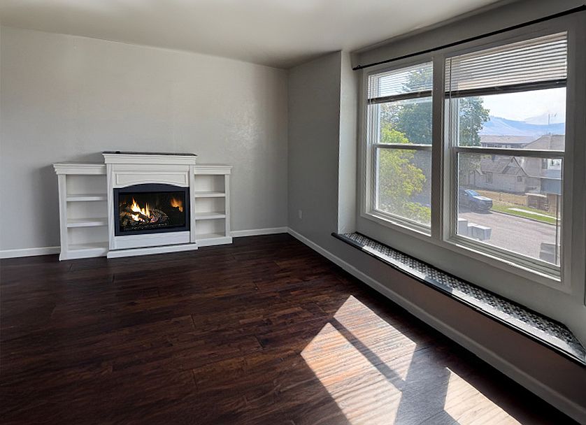 living room area with large windows with street view and natural gas fire place.