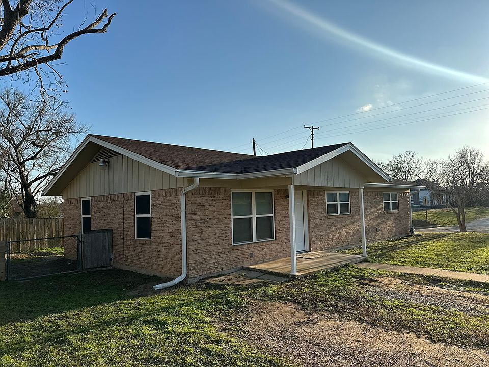 Front view of house. Gate to backyard on the left.