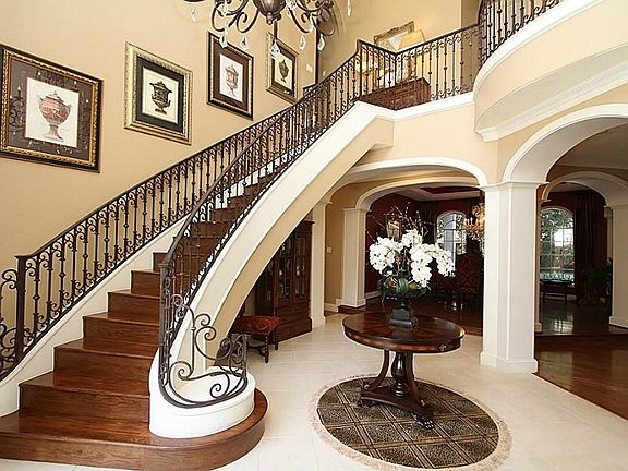  Grand two-story foyer with beautiful chandelier an wrought iron staircase