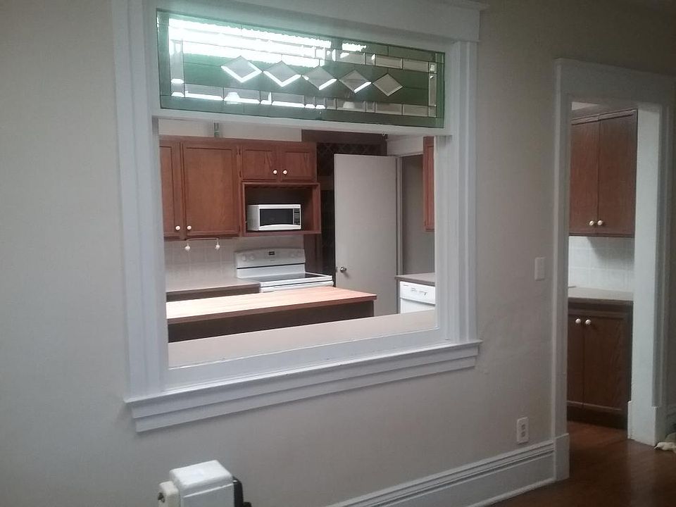 Stain glass, kitchen view from foyer. Beautiful trim throughout.