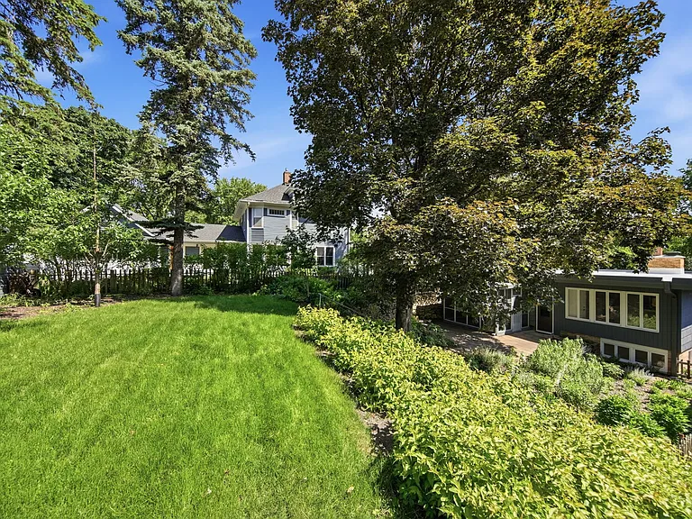 Very private and quiet back yard. Upper portion of yard on left (grass field with 2 apple and 2 cherry trees), lower portion of yard on right.